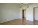 Wood floors in a bedroom with a ceiling fan, showing closet, and hall to the bathroom at 945 N Pasadena -- # 84, Mesa, AZ 85201