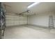 Spacious garage with roll-up door, overhead lighting, and ample storage for vehicles and tools at 945 N Pasadena -- # 84, Mesa, AZ 85201