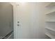 A pantry with bright white walls and shelving offers practical storage solutions next to a stainless refrigerator at 945 N Pasadena -- # 84, Mesa, AZ 85201