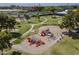 Aerial view of a community playground equipped with slides, swings, and play structures, surrounded by grassy areas at 945 N Pasadena -- # 84, Mesa, AZ 85201