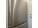 Close-up of stainless steel refrigerator next to a closed door in a brightly lit space at 945 N Pasadena -- # 84, Mesa, AZ 85201