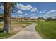 Picturesque view of a community walking path meandering through lush green spaces on a beautiful, sunny day at 945 N Pasadena -- # 84, Mesa, AZ 85201