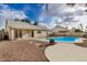 View of a backyard swimming pool with rock landscaping, covered patio, and outdoor grill at 10208 W Highland Ave, Phoenix, AZ 85037