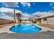 Backyard pool surrounded by concrete patio and desert landscaping, with palm trees and covered patio at 10208 W Highland Ave, Phoenix, AZ 85037