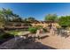 Spacious backyard features a patio with multiple seating areas, desert landscaping, and a pergola at 1322 W Spur Dr, Phoenix, AZ 85085
