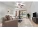 Bright living room with a ceiling fan, a sliding door to the yard, and a large patterned rug at 1322 W Spur Dr, Phoenix, AZ 85085