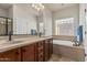 Main bathroom features double sinks, granite countertops, soaking tub, and a glass block window at 1322 W Spur Dr, Phoenix, AZ 85085
