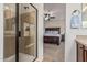 En suite bathroom leads to a main bedroom with large bed, ceiling fan, carpet, and natural light at 1322 W Spur Dr, Phoenix, AZ 85085
