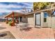 Covered back patio featuring brick pavers and an outdoor dining set for enjoyable al fresco meals at 2017 E Willis Rd, Gilbert, AZ 85297