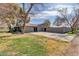 Spacious backyard featuring a patio, mature trees, and a neutral stucco wall for privacy at 2017 E Willis Rd, Gilbert, AZ 85297