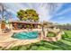 A lush backyard featuring a sparkling pool, covered patio, and mature landscaping at 2017 E Willis Rd, Gilbert, AZ 85297