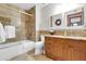 The bathroom features a bath tub with shower, granite counters and wooden cabinets at 2017 E Willis Rd, Gilbert, AZ 85297