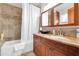 Bathroom featuring a shower, bathtub, tiled walls and wooden vanity with granite countertop at 2017 E Willis Rd, Gilbert, AZ 85297