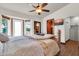 Bright bedroom features white walls, a ceiling fan, and a door to the backyard at 2017 E Willis Rd, Gilbert, AZ 85297