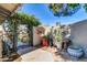 Charming courtyard featuring an ornate gate, lush greenery, and unique decorative elements at 2017 E Willis Rd, Gilbert, AZ 85297