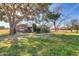 Expansive front yard showcasing mature trees, lawn, and a charming home facade with stone accents at 2017 E Willis Rd, Gilbert, AZ 85297