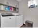 A laundry room with a side-by-side washer and dryer, upper cabinets and a small window at 2017 E Willis Rd, Gilbert, AZ 85297