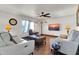 Comfortable living room featuring neutral furniture, a ceiling fan, and a large window at 2017 E Willis Rd, Gilbert, AZ 85297