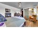 This is a view of the main bedroom with a ceiling fan, a barn door and a woven chair at 2017 E Willis Rd, Gilbert, AZ 85297