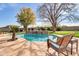 The backyard features a private pool with waterfall, palm trees, a seating area, and a privacy fence at 2017 E Willis Rd, Gilbert, AZ 85297