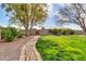Beautifully maintained front yard featuring a brick walkway, expansive lawn, and lush trees at 2017 E Willis Rd, Gilbert, AZ 85297
