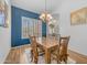 Stylish dining room with a wooden table and blue accent wall, illuminated by a modern chandelier at 3060 N Ridgecrest -- # 200, Mesa, AZ 85207