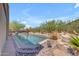 Picturesque backyard pool area with a rock border, desert plants, and mountain views at 3060 N Ridgecrest -- # 200, Mesa, AZ 85207