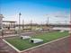 Outdoor game area with cornhole boards, benches, and manicured landscaping, perfect for community gatherings at 36956 W Santa Maria St, Maricopa, AZ 85138