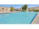Community pool with lounge chairs and nearby condos offer a relaxing outdoor space at 6953 E Osborn Rd # F, Scottsdale, AZ 85251