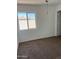 Bedroom with carpet, window, and white walls, awaits personalization, offers ample natural light, and renovation potential at 11918 W Aster Dr, El Mirage, AZ 85335