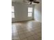 A bedroom featuring tiled floor, two windows, and a ceiling fan at 11918 W Aster Dr, El Mirage, AZ 85335