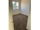 A small bedroom with neutral carpeting, white walls, and a window at 11918 W Aster Dr, El Mirage, AZ 85335