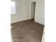 A bedroom with stained carpet, white walls, and a window to provide light at 11918 W Aster Dr, El Mirage, AZ 85335