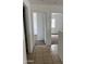 Hallway with tile flooring leading to carpeted bedrooms at 11918 W Aster Dr, El Mirage, AZ 85335