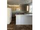 An open kitchen with white appliances, light wood cabinets, and tiled floors at 11918 W Aster Dr, El Mirage, AZ 85335