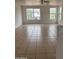 Spacious living room featuring tile flooring and natural lighting from large windows at 11918 W Aster Dr, El Mirage, AZ 85335