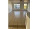 A spacious living room featuring tile floors, white walls, large windows and natural light at 11918 W Aster Dr, El Mirage, AZ 85335