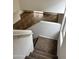 Carpeted staircase leading down to a living area with neutral tile flooring at 11918 W Aster Dr, El Mirage, AZ 85335