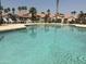 Community pool area with lounge chairs, palm trees and several single-story residential homes at 1502 W Wagner Dr, Gilbert, AZ 85233