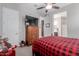 Bedroom featuring a ceiling fan, large dresser and a view of the ensuite bath at 2393 N Beverly Pl, Buckeye, AZ 85396
