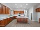Modern kitchen with rich wood cabinetry, stainless steel appliances, and a central island with marble countertop at 2620 W Piedmont Rd, Phoenix, AZ 85041