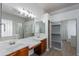 Bright bathroom boasts double sinks, a walk-in shower, a large mirror, and a walk-in closet at 2620 W Piedmont Rd, Phoenix, AZ 85041