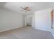 Bright main bedroom features neutral carpet, ceiling fan, and an entrance to an ensuite bathroom and walk-in closet at 2620 W Piedmont Rd, Phoenix, AZ 85041