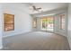 Expansive main bedroom with access to the backyard pool area, three windows, and neutral carpet at 2620 W Piedmont Rd, Phoenix, AZ 85041