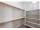 Spacious walk-in closet featuring white walls, shelving, carpeted flooring, and a small window at 2620 W Piedmont Rd, Phoenix, AZ 85041