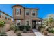 Two-story townhome showcasing neutral stucco, dark shutters, and desert landscaping at 2640 N Heritage St, Buckeye, AZ 85396