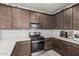 Close up of kitchen with stainless steel appliances, quartz counters, modern backsplash, and dark wood cabinets at 2640 N Heritage St, Buckeye, AZ 85396