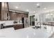 Spacious kitchen featuring stainless steel appliances, quartz countertops, modern backsplash, and dark wood cabinets at 2640 N Heritage St, Buckeye, AZ 85396