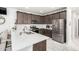 Stylish kitchen featuring stainless steel appliances, quartz countertops, modern backsplash, and dark wood cabinets at 2640 N Heritage St, Buckeye, AZ 85396
