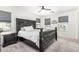 Spacious main bedroom with a striking black headboard, neutral carpet, and ample natural light from multiple windows at 2640 N Heritage St, Buckeye, AZ 85396